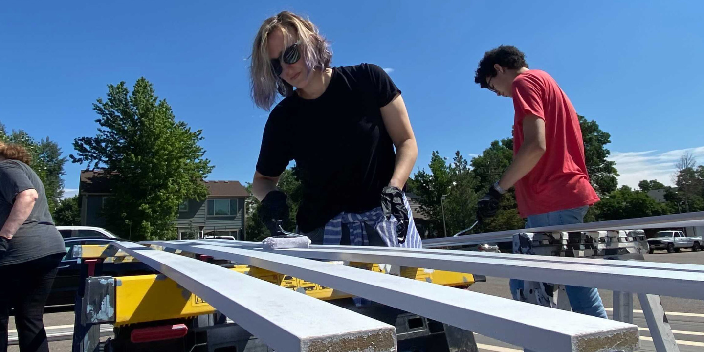 Limina staff painting baseboards for Anchor House